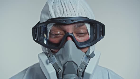 Close-up Portrait of Serious Tired Doctor in Protective Medical Suit , Respirator and Goggles