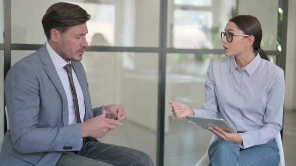 Young Female with Tablet  Counseling Angry Middle Aged Businessman