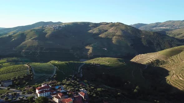 Flying forward and tilting down from an aerial vantage to view a Portuguese manor atop a hill in the