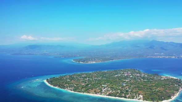 Aerial drone seascape of idyllic coast beach adventure by blue green ocean with white sandy backgrou