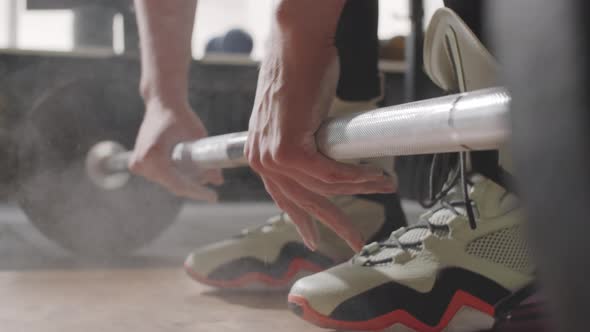 Woman Applying Chalk Powder and Taking Barbell alt