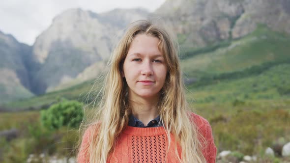 Caucasian woman having a good time on a trip to the mountains, looking at camera and smiling