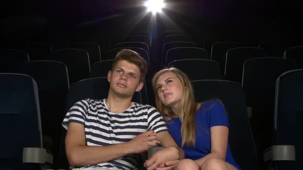 Young Couple Feeding Each Other at the Cinema