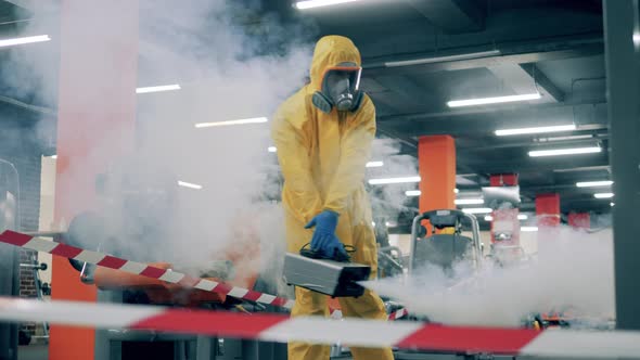 Man in Hazmat Disinfects Gym with a Sprayer