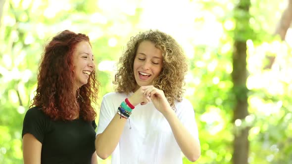 Two girls playing at park and making mustache with their hair