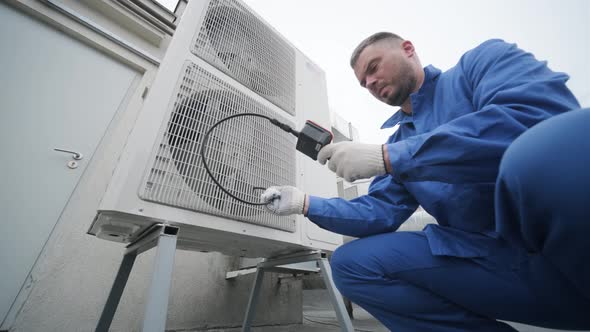 The technician uses a digital camera to check the clogging of the heat exchanger