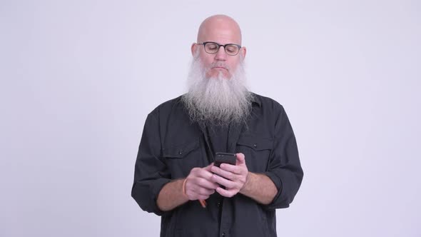 Mature Bald Bearded Man Using Phone