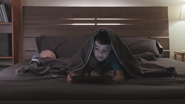 Asian Boy Watching Cartoon on Tablet before Bedtime