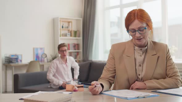 Female Therapist Filing Papers at Appointment