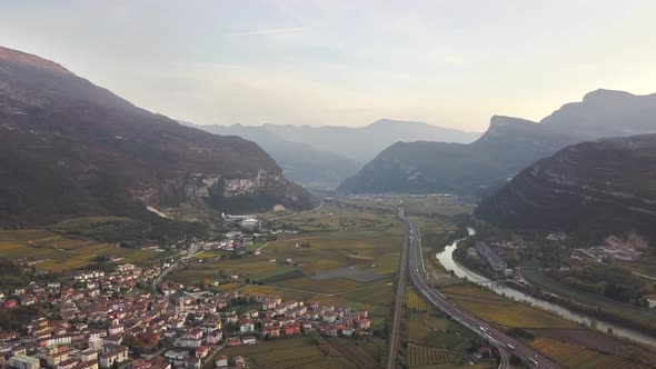 Aerial view of freeway interstate road in italian alps with fast moving traffic and rural green