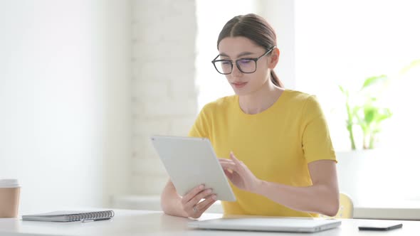Woman using Tablet while Sitting in Office