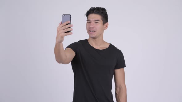 Happy Young Handsome Multi-ethnic Man Video Calling and Showing Phone