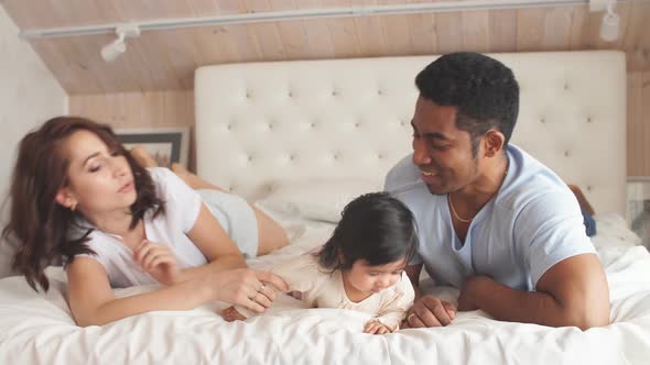 Young Multi-ethnic Family Playing in Bed