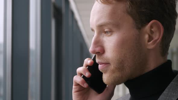 Portrait handsome man having phone talk in office. Business man talking on smartphone. Office employ