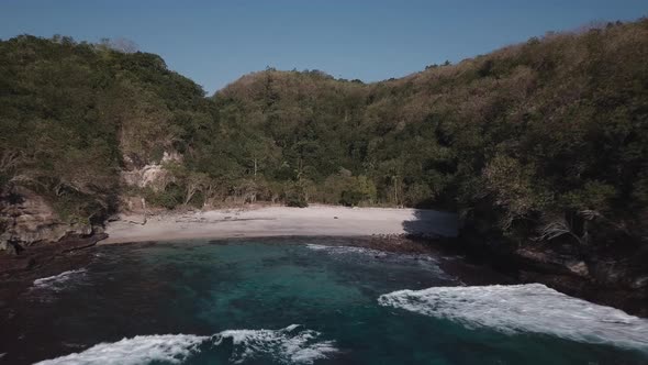 Aerial View of Tropical Beach with Azure Blue Water and Foaming Ocean Waves