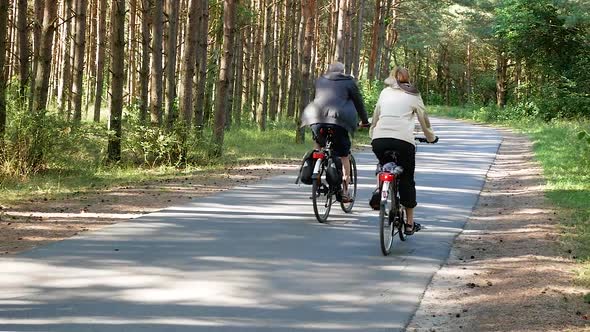 Smiling Couple Cycling Through a Forest Together, Close Up