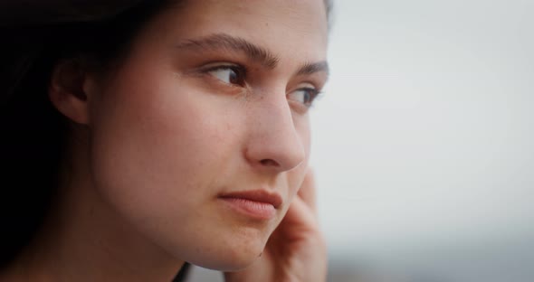 A Young Woman Puts Wireless Headphones in Her Ears