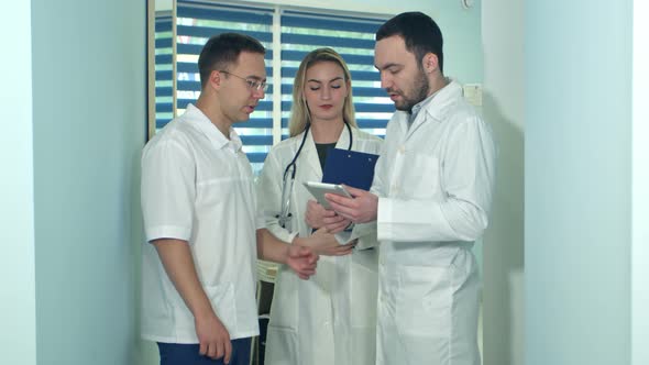 Male Doctor Showing Something on Tablet To His Colleagues