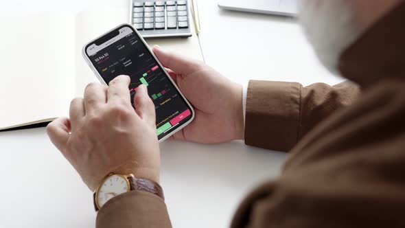 man is exploring a stock market on his phone