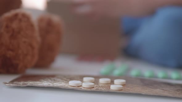 Kid Plays with Scattering Medicine Drugs. Toddler Touches Pills Without Parent Control. Dangerous