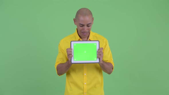 Happy Handsome Bald Businessman Showing Digital Tablet and Looking Surprised