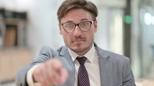 Portrait of Assertive Businessman with Pointing at the Camera