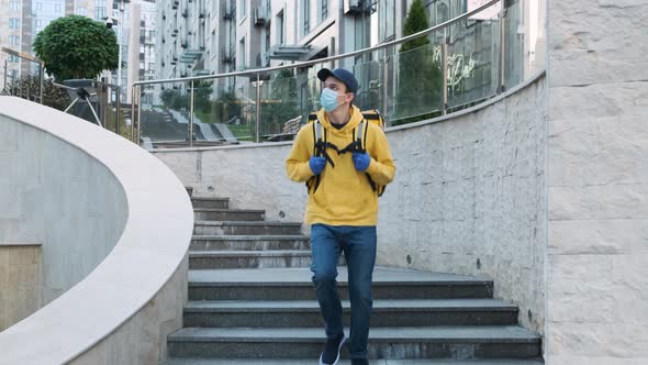 Courier of Food Delivery Service Walking Down the Stairs in the Modern Stylish Business District