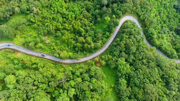 Aerial view of road on mountains and forest.