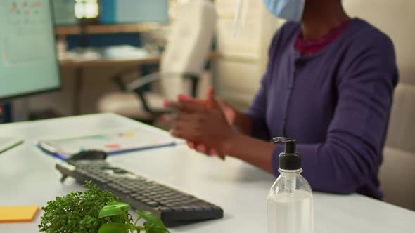 Close Up of Black Woman Using Hand Sanitizer in Office