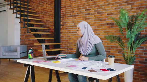 Arab Woman in Lavender Hijab Designs the Interior of an Apartment or House