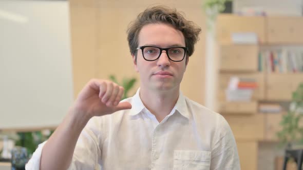 Portrait of Young Man Showing Thumbs Down Gesture