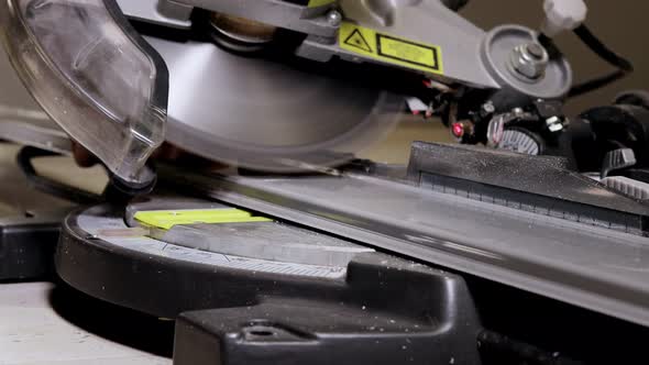 Worker cutting baseboard on the circular saw before installing.