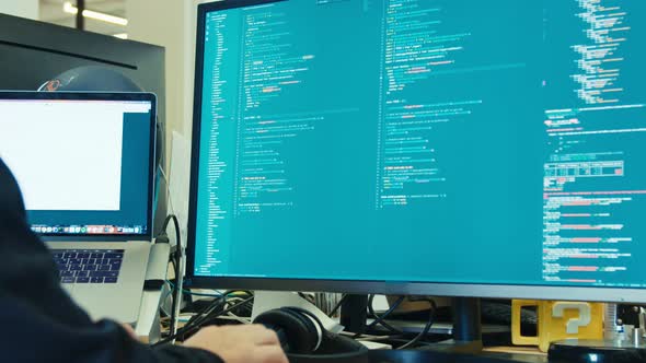 computer programmer sitting in front of a screen coding software