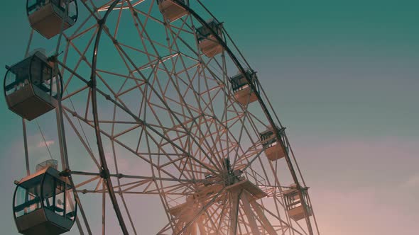 Close Up of Rotating Ferris Wheel on Background Sunset