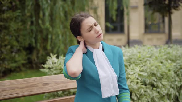 Portrait of Young Professional Stewardess Having Neck Pain. Tired Slim Caucasian Woman in Blue