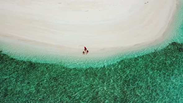 Beautiful fun women on vacation in the sun on the beach on sunny blue and white sand 4K background