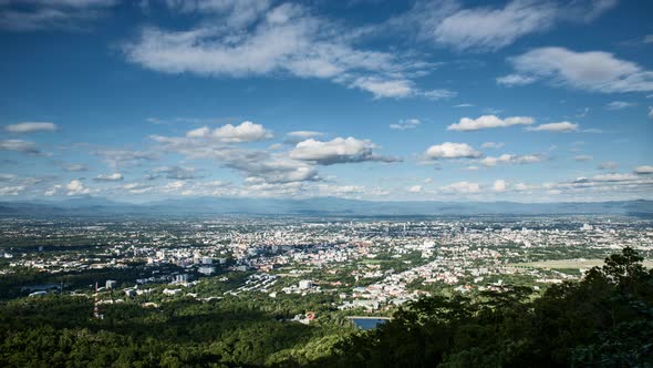 clouds moving through blue sky over chiang mai city in mountainous scenery, time lapse