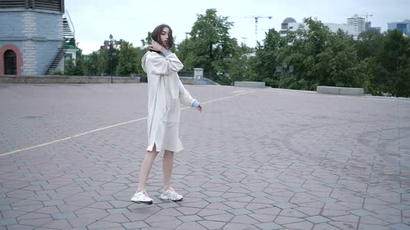 A Young Female Student Walks Around the City in Warm Windy Weather