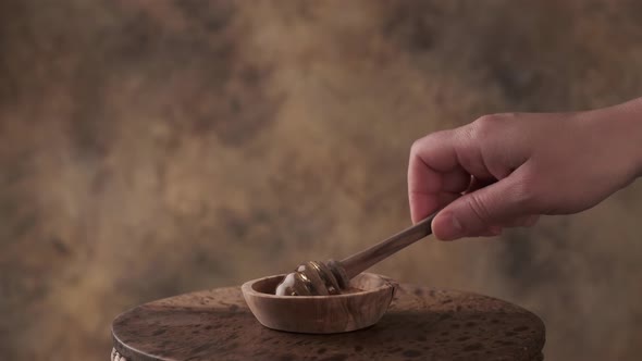 Honey Dripping, Pouring from Honey Dipper in Wooden Bowl