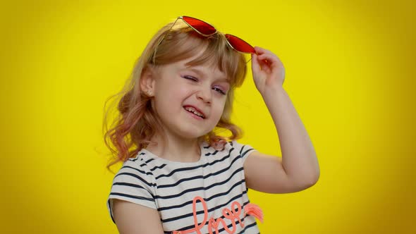 Funny Playful Blonde Kid Child Wearing Sunglasses Blinking Eye Looking with Charming Smile