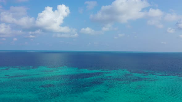 Tropical birds eye tourism shot of a white sandy paradise beach and blue ocean background in colourf