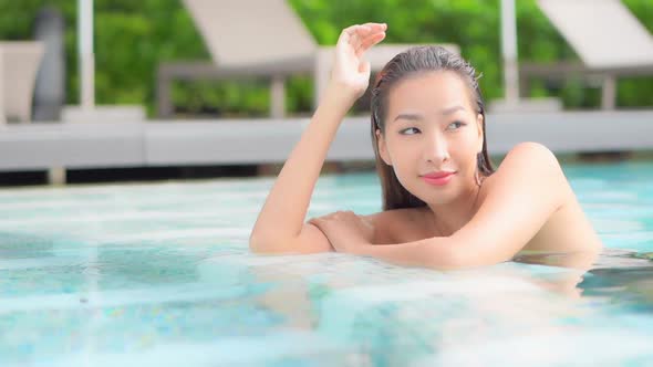 Young asian woman enjoy around outdoor swimming pool for leisure