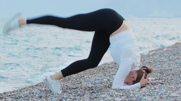 Sports Outdoors  a Fitness Woman Doing Gymnastics Exercise By the Sea  Handstand