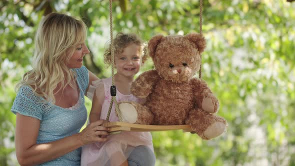 Spring and happy summer time. Joyful and smiling mom with her blue eyed little girl daughter child