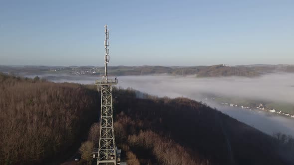 One person standing on top of a steel observation tower taking in the beautiful view at sunrise. Aer