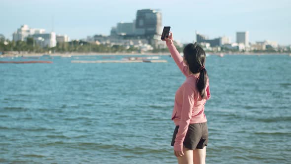 Beautiful sports girl using a smartphone video chatting with friends after running.