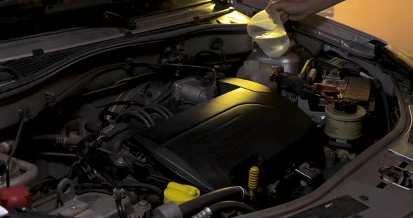 Putting water in the radiator reservoir in the car engine