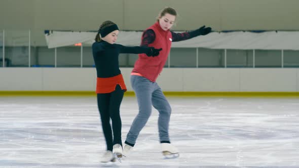 Figure skating coach showing steps and turnings on ice