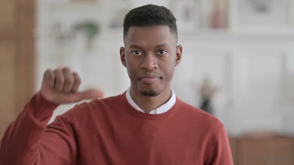 Portrait of African Man showing Thumbs Down at Home