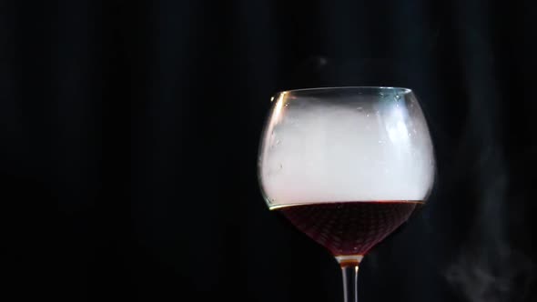 Glass filled with cola and smoke close up on a black background